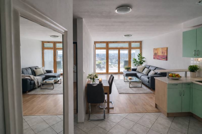 Living room in a two-room apartment with a wood-patterned floor and a comfortable sofa.