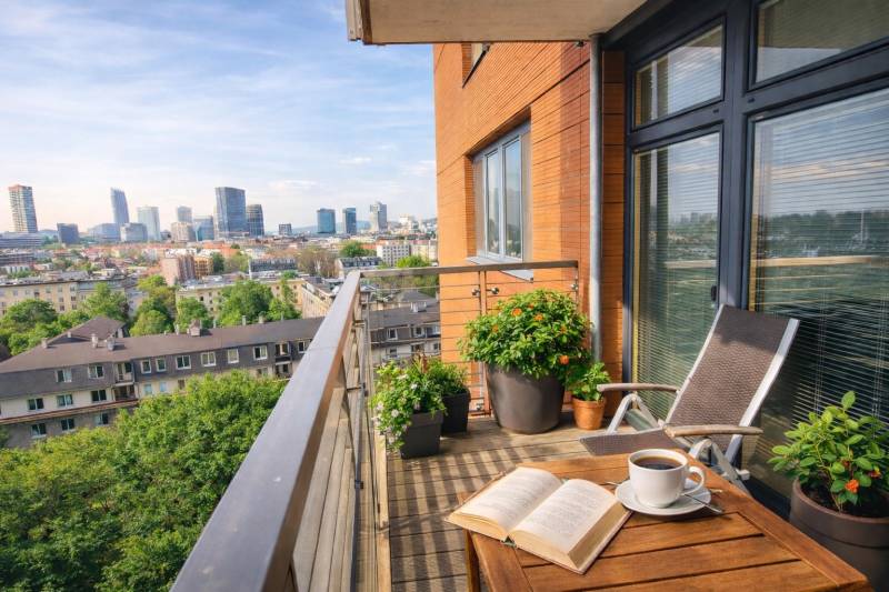 A balcony with a view of the panorama of Bratislava from a 2-room apartment with a wooden decor floor.
