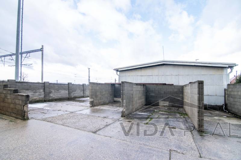 In Šenkvice on Nádražná Street, the photograph shows warehouses and halls with solid concrete walls.