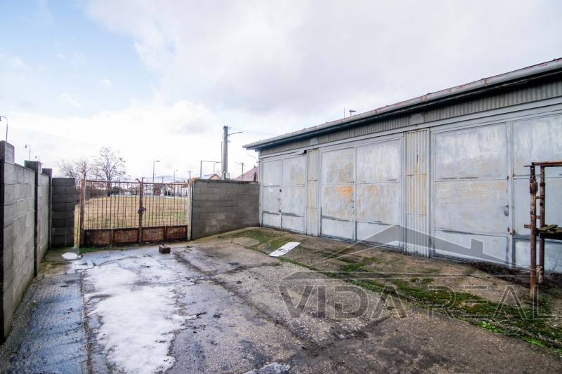 Gate and metal warehouse with a concrete area on Nádražná Street in Šenkvice.