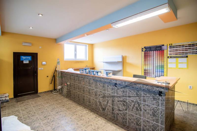 Interior of a store in warehouses and halls with a counter, shelves, and color samples on the wall.