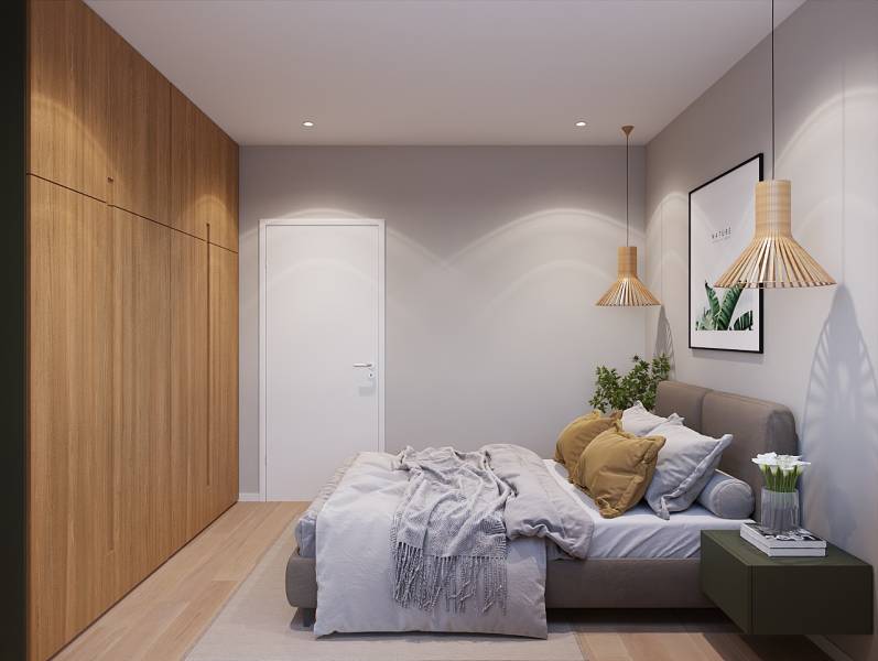 Bedroom in a studio apartment with a bed, a plant, and wooden decor on the floor.