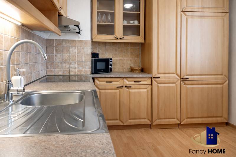 A kitchen in a 3-room apartment with wooden decor and modern equipment.