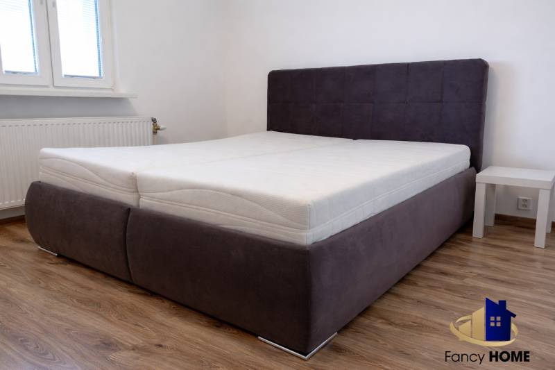 Bedroom with a bed and wooden decor flooring in a 3-room apartment.