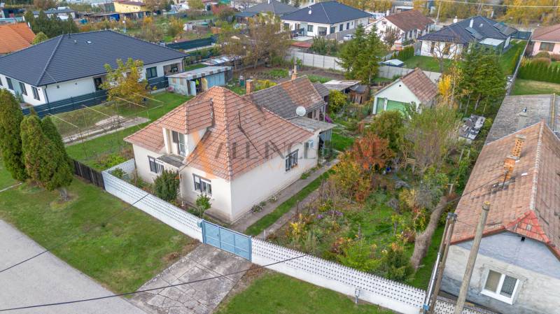 A family house in Veľké Dvorníky with a landscaped garden and surrounding greenery.