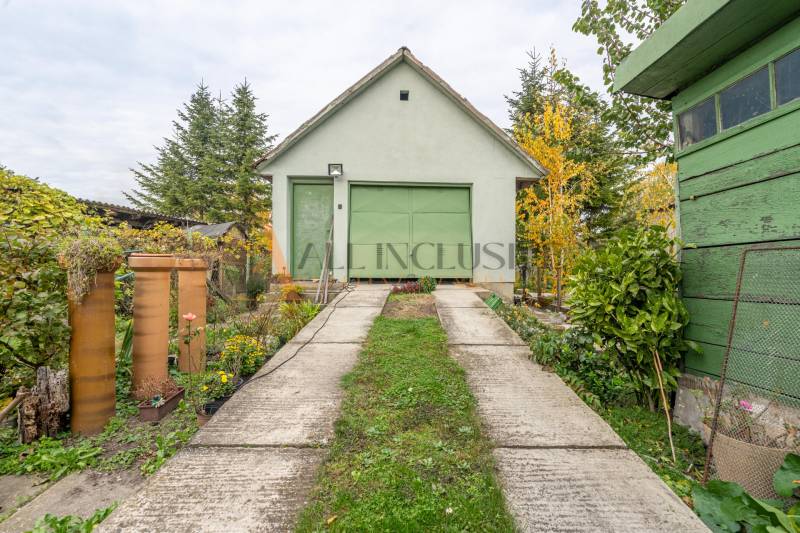 The courtyard of a family house in Veľké Dvorníky with a garage and greenery.