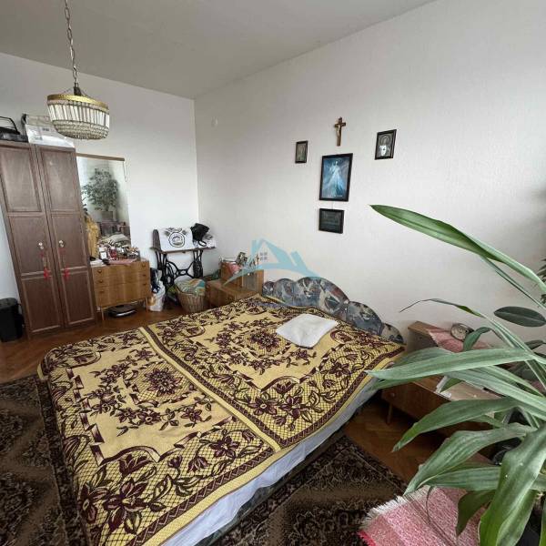 A bedroom in a 4-room apartment with carpet, decorations, and a wooden decor floor.