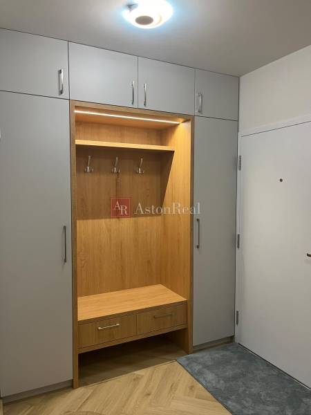 Built-in wardrobe with a hanger, wooden decor flooring in a 3-room apartment.