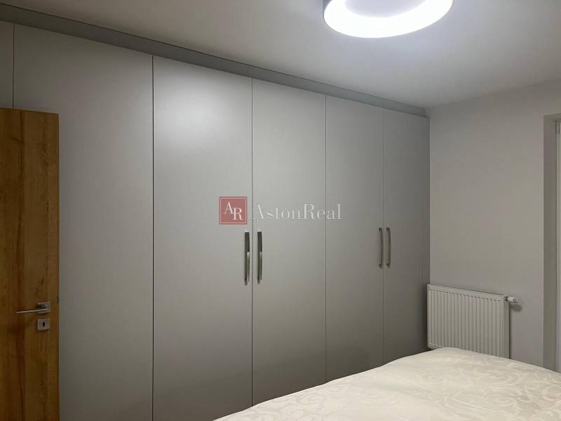 In the 3-room apartment, there are wardrobes with white sliding doors and a bed.