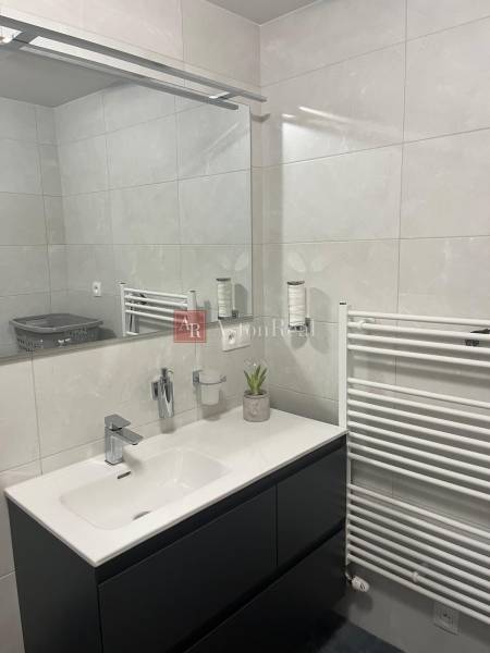 Bathroom in a 3-room apartment with a modern sink, mirror, and radiator.