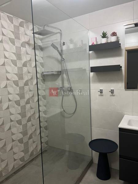A bathroom in a 3-room apartment with a barrier-free shower and modern tiles.
