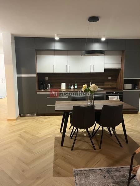 A kitchen in a 3-room apartment with gray cabinets and a wooden decor floor.