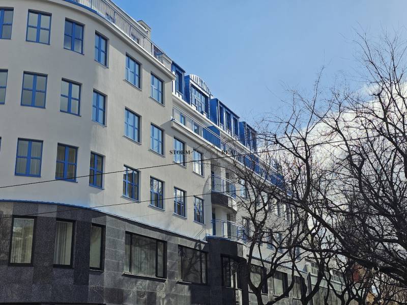 A building in Bratislava - Old Town on Poštová Street with trees in the foreground.