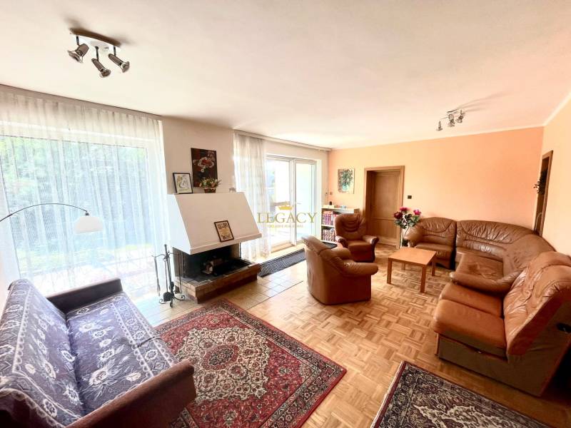 Living room with a fireplace and a leather sofa set in a family house.