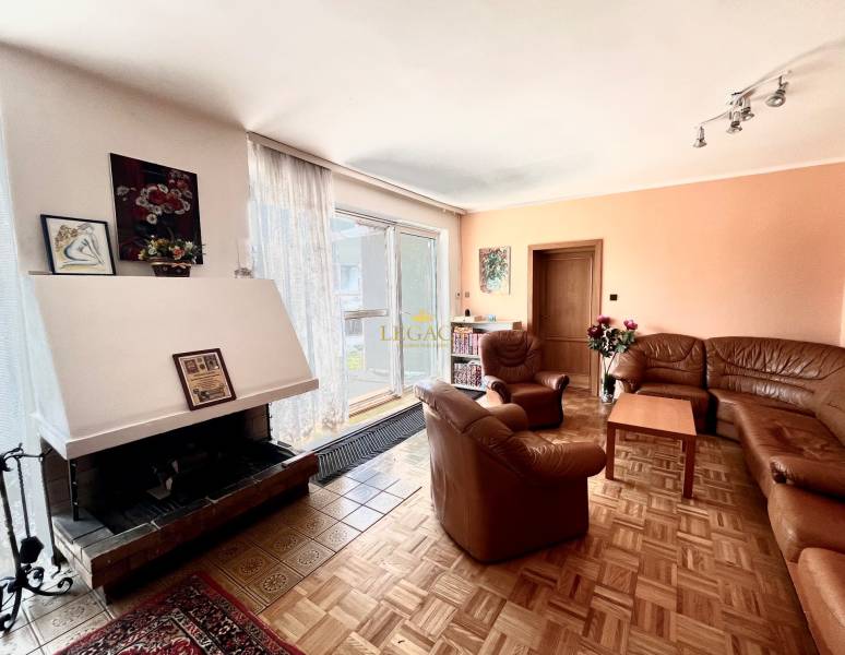 Family house with a fireplace, sofas, pictures on the wall, and a floor with a wooden decor.