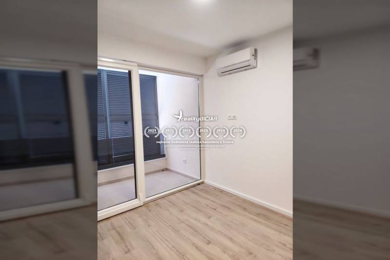 A room in a family house with air conditioning, wooden decor flooring, and sliding doors to the terrace.