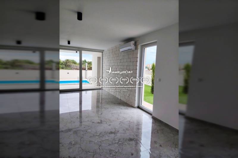 The interior of a family house with air conditioning, large windows, and a view of the pool.