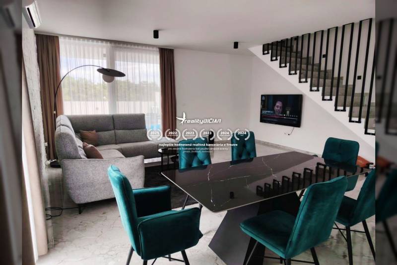 Living room in a family house with a dark table and turquoise chairs.