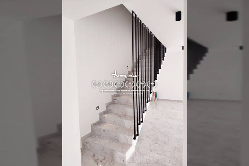 A staircase with marble decor and metal railing in a family house.