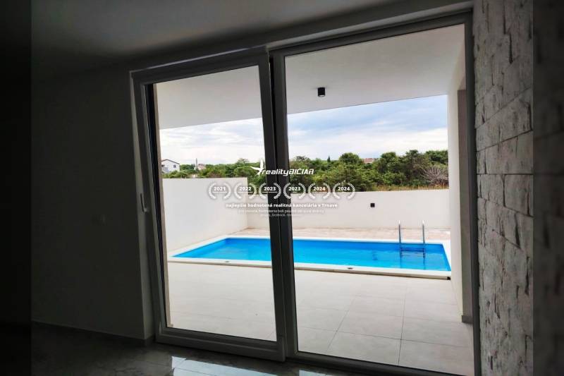 View from the family house to the terrace with a pool, floor with wooden decor.