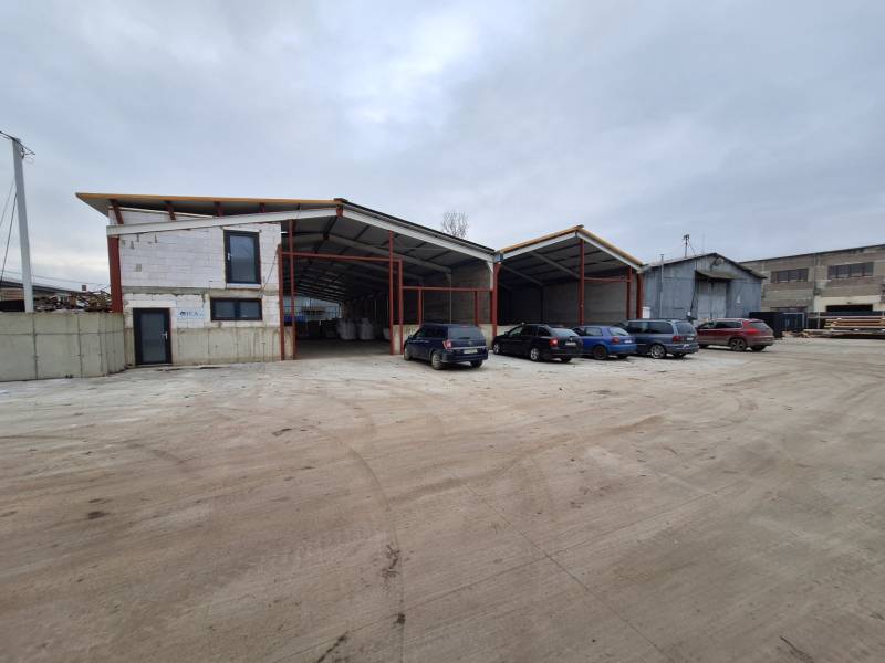 Warehouse and hall space on Strojnícka Street in Prešov with a parking lot and cars.