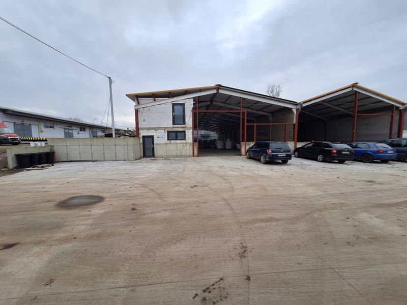 Industrial building on Strojnícka Street in Prešov with parking spaces and cars.