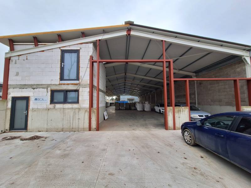 Warehouses and halls on Strojnícka Street in Prešov with a car in front of the building.