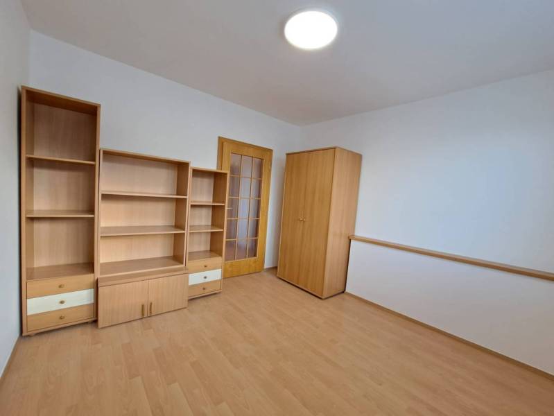 A room in a 4-room apartment with furniture and a floor with a wood decor.