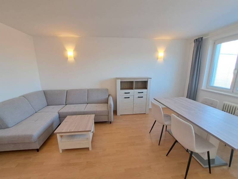 Living room in a 4-room apartment with a corner sofa and a dining table.