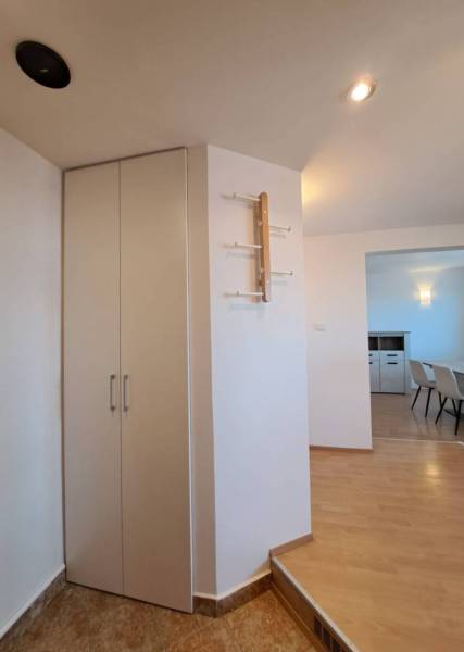 Interior of a 4-room apartment with a wooden decor floor and a modern wall hanger.