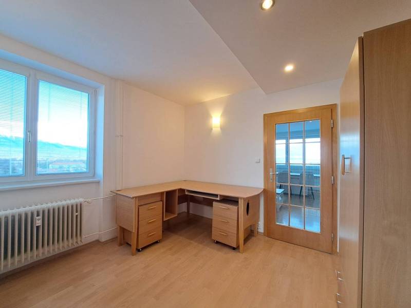 A study in a 4-room apartment with a wood-patterned floor and a writing desk.