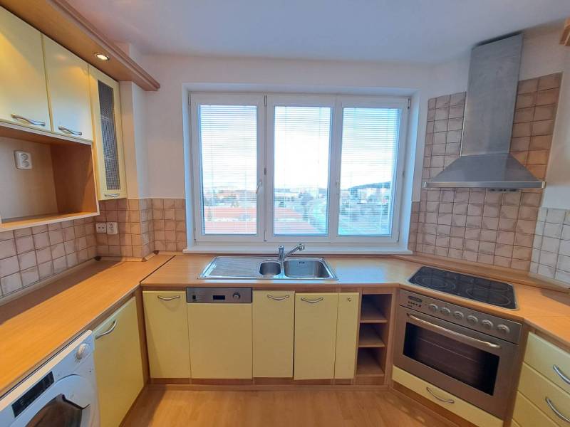 A kitchen in a 4-room apartment with a wood-patterned floor and a view of the city.