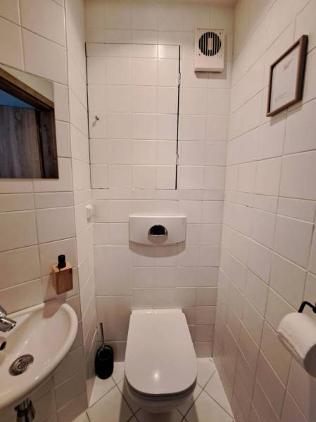 A bathroom with standard white tiles and a sink in a 4-room apartment.