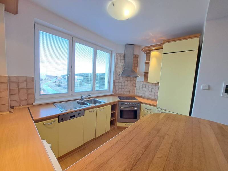 A kitchen in a 4-room apartment with built-in appliances and a floor with a wooden decor.