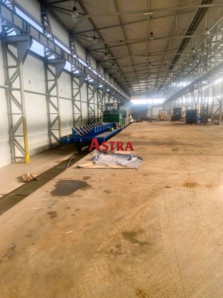 Production facilities with railway tracks, steel structures, and stored materials.