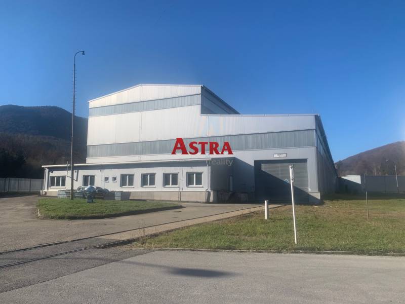 Production facilities in Dobšiná with a steel structure surrounded by natural scenery and grassy areas.