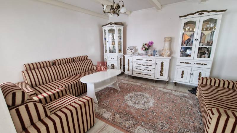 Living room of a family house with a striped sofa and white cabinets.