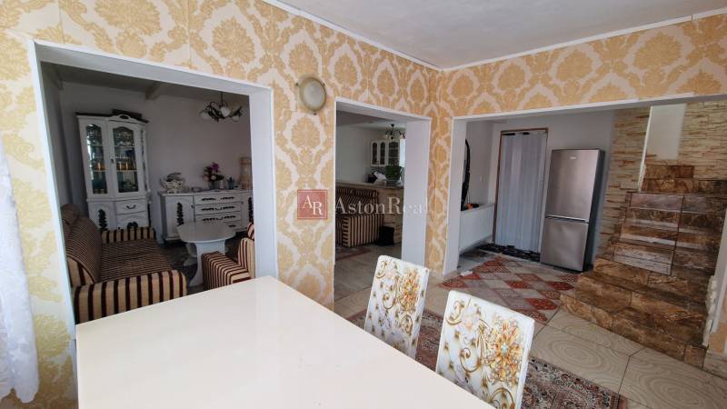 Interior of a family house with rich patterns, a kitchen, and a seating area.