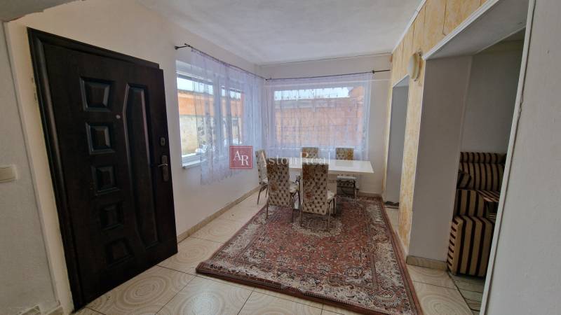 A bright dining room with large windows in a family house.
