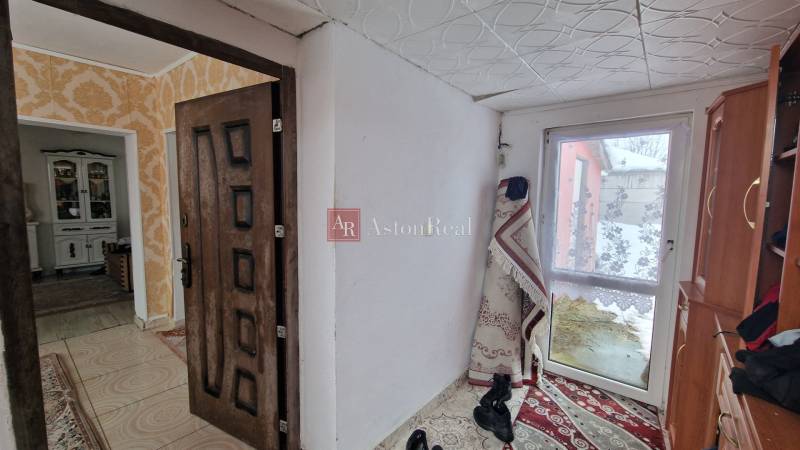 Entrance hall with carpet and wood paneling in a family house.