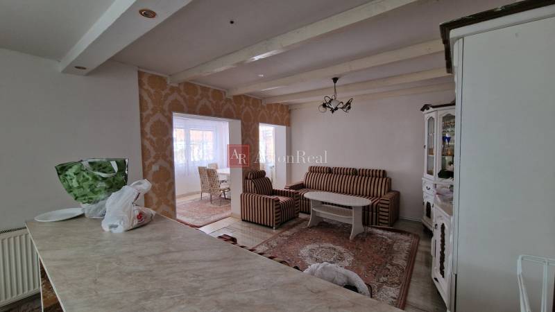 Living room in a family house with striped sofas, a table, and a decorative wall.