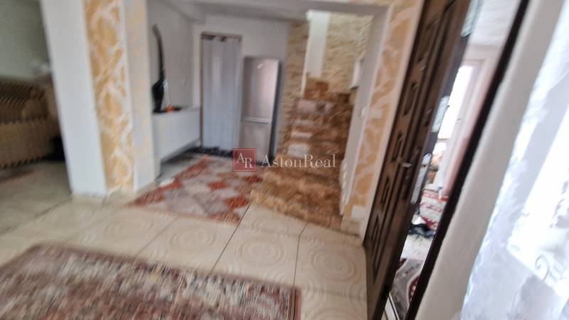 Family house with a staircase, carpet, and patterned floor with a wooden decor.