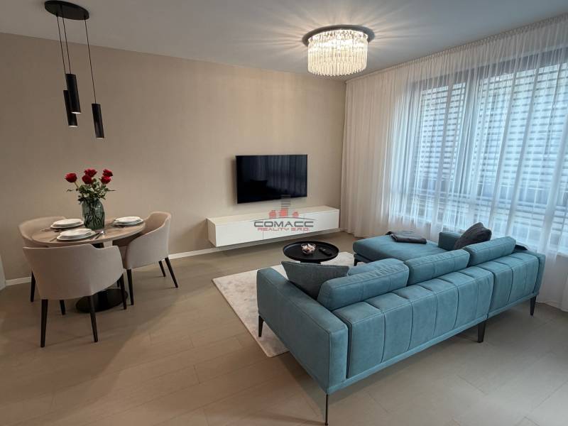 Living room in a two-room apartment with a wooden decor floor and comfortable seating.