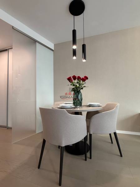 Dining area with a table and chairs, wooden decor flooring in a 2-room apartment.