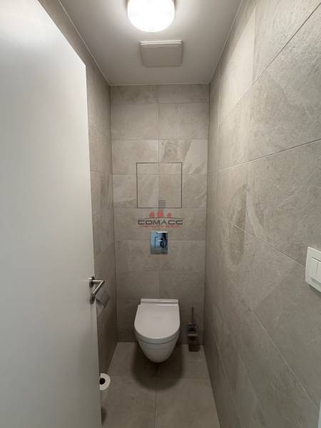 A bathroom in a 2-room apartment with tiles in soft shades.