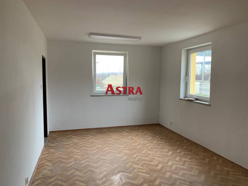 An empty room with two windows and a wooden decor floor in warehouses and halls.
