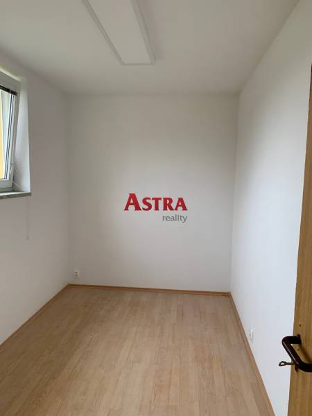 A small room with white walls and a floor with a wood decor.