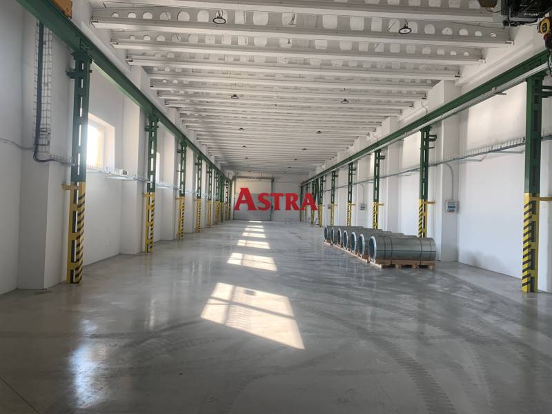 Interior of a warehouse and hall with steel coils on a concrete floor.