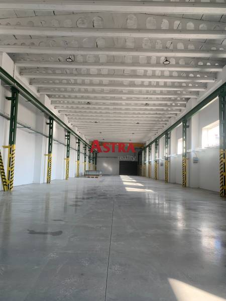 Spacious interior of a warehouse and hall with a reinforced concrete ceiling and smooth concrete floor.