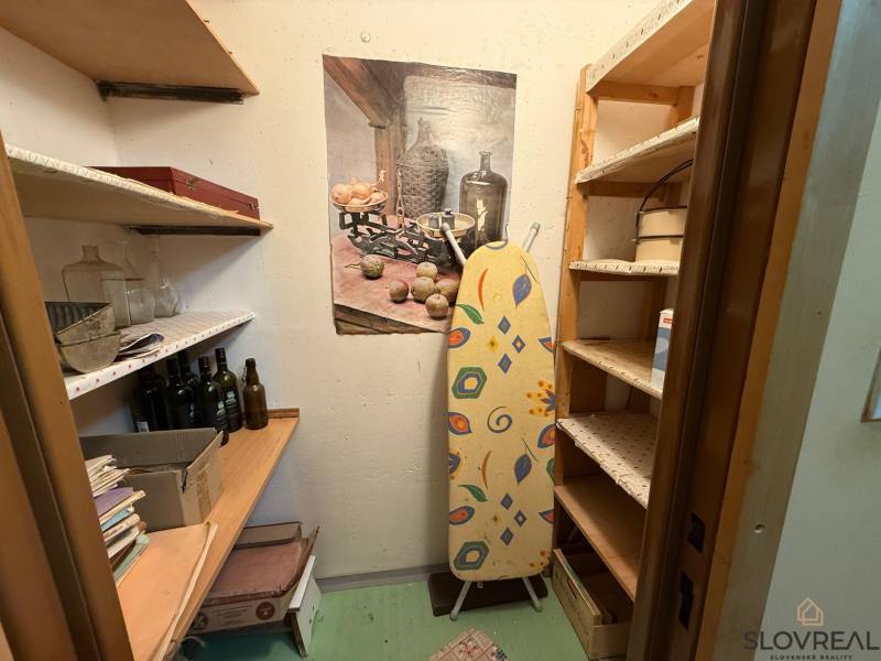 Storage space with shelves and an ironing board in a 3-room apartment.
